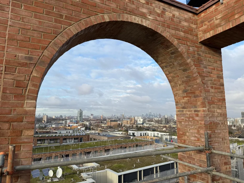 blue sky london skyline behind decorative brick arch lintel
